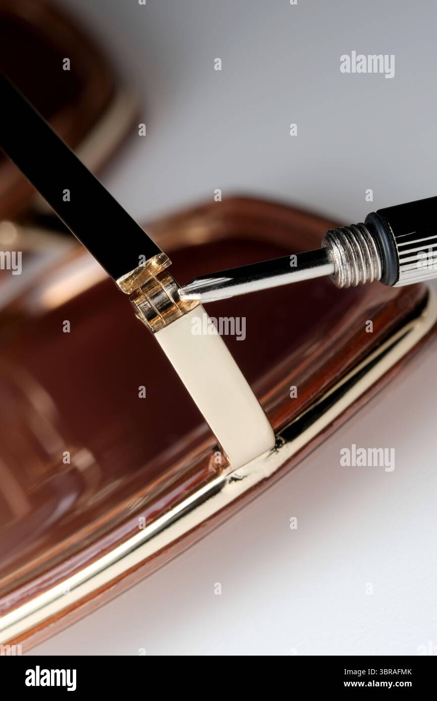 Ein erfahrener Handwerker montiert sorgfältig Komponenten für Luxusbrillen. Stockfoto