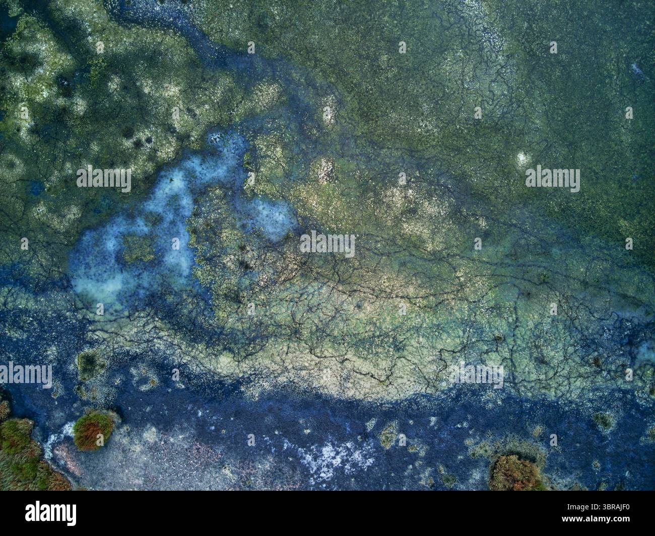 Aus der Vogelperspektive eines Wandteppichs aus Petrol und Smaragdwasser verschmelzen sich mit Erdtönen und bilden ein faszinierendes Mosaik der Naturkunst, Kalochori, Thessaloniki, Griechenland. Stockfoto