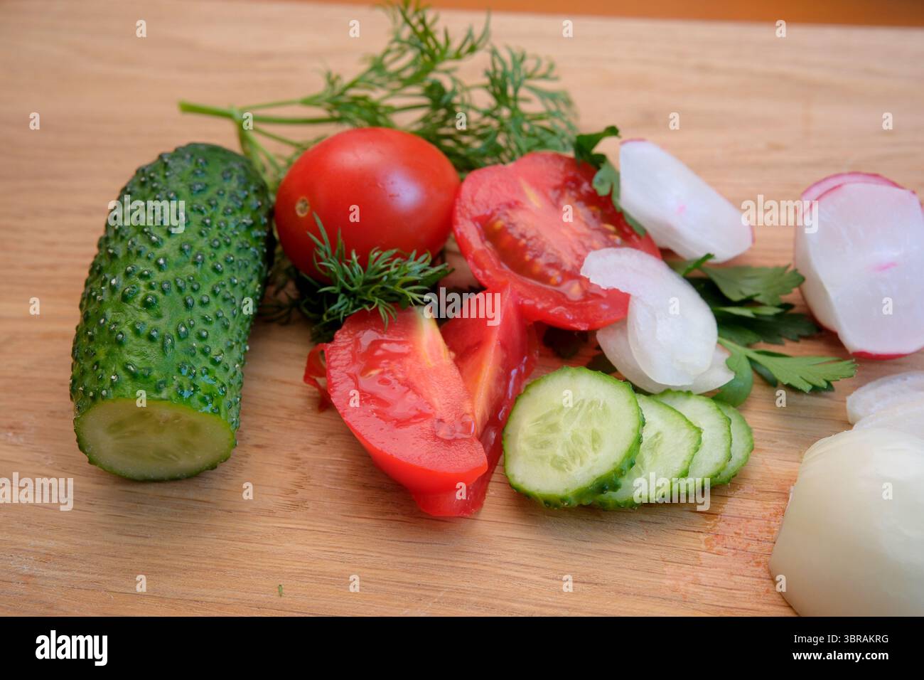 Bunte Auswahl an geschnittenem Gemüse auf einem Holzbrett. Stockfoto