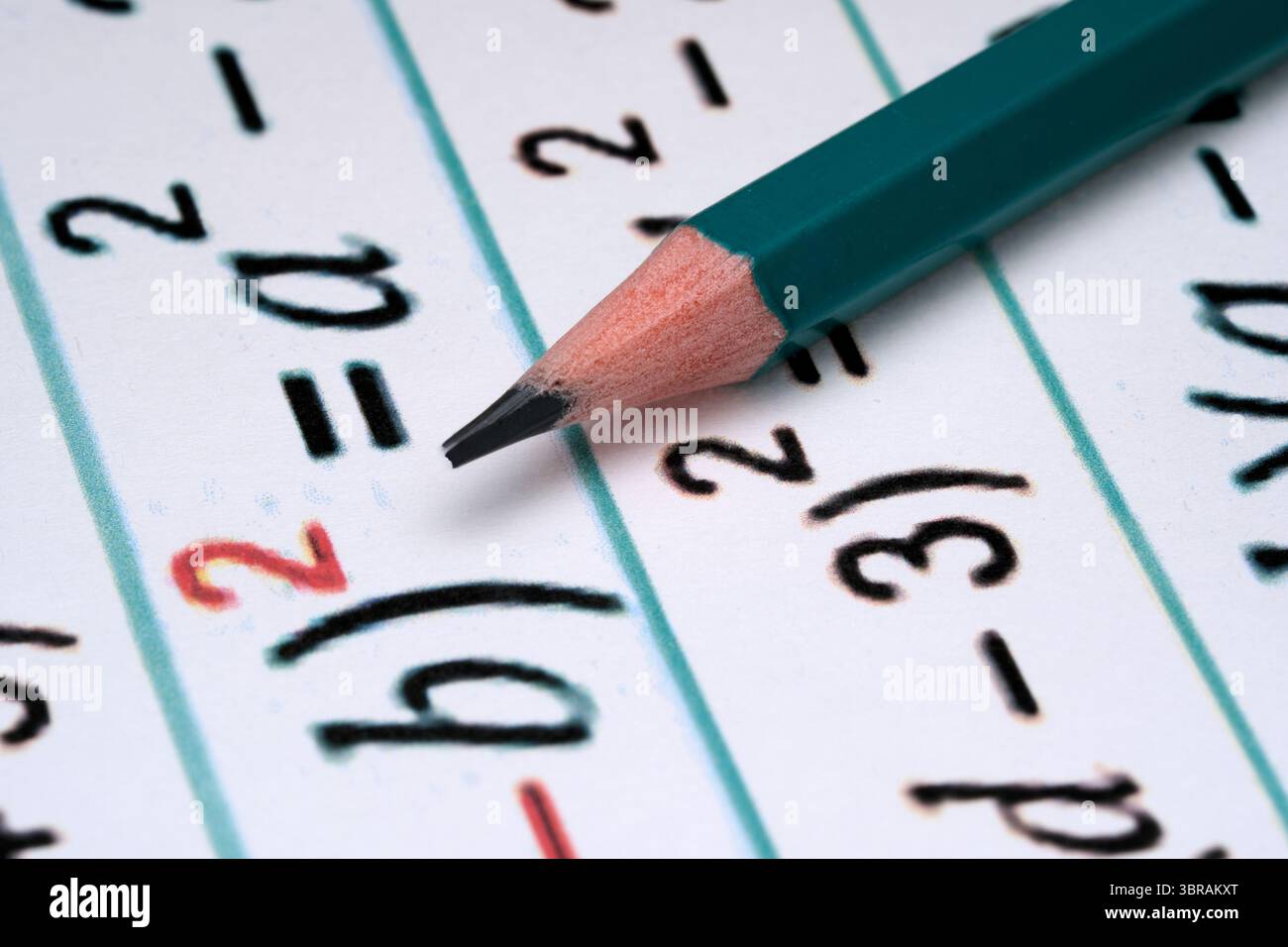Ein genauer Blick auf einen Bleistift, der auf mathematischen Gleichungen ruht, perfekt zum Lernen. Stockfoto