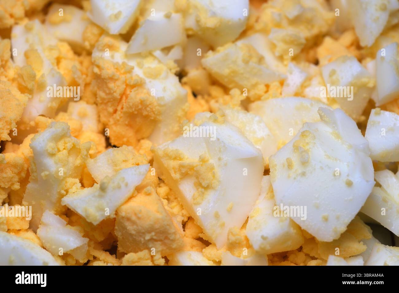 Herzhafte Stücke hartgekochter Eier sorgen für eine lebendige Textur, die perfekt für Gerichte geeignet ist. Stockfoto