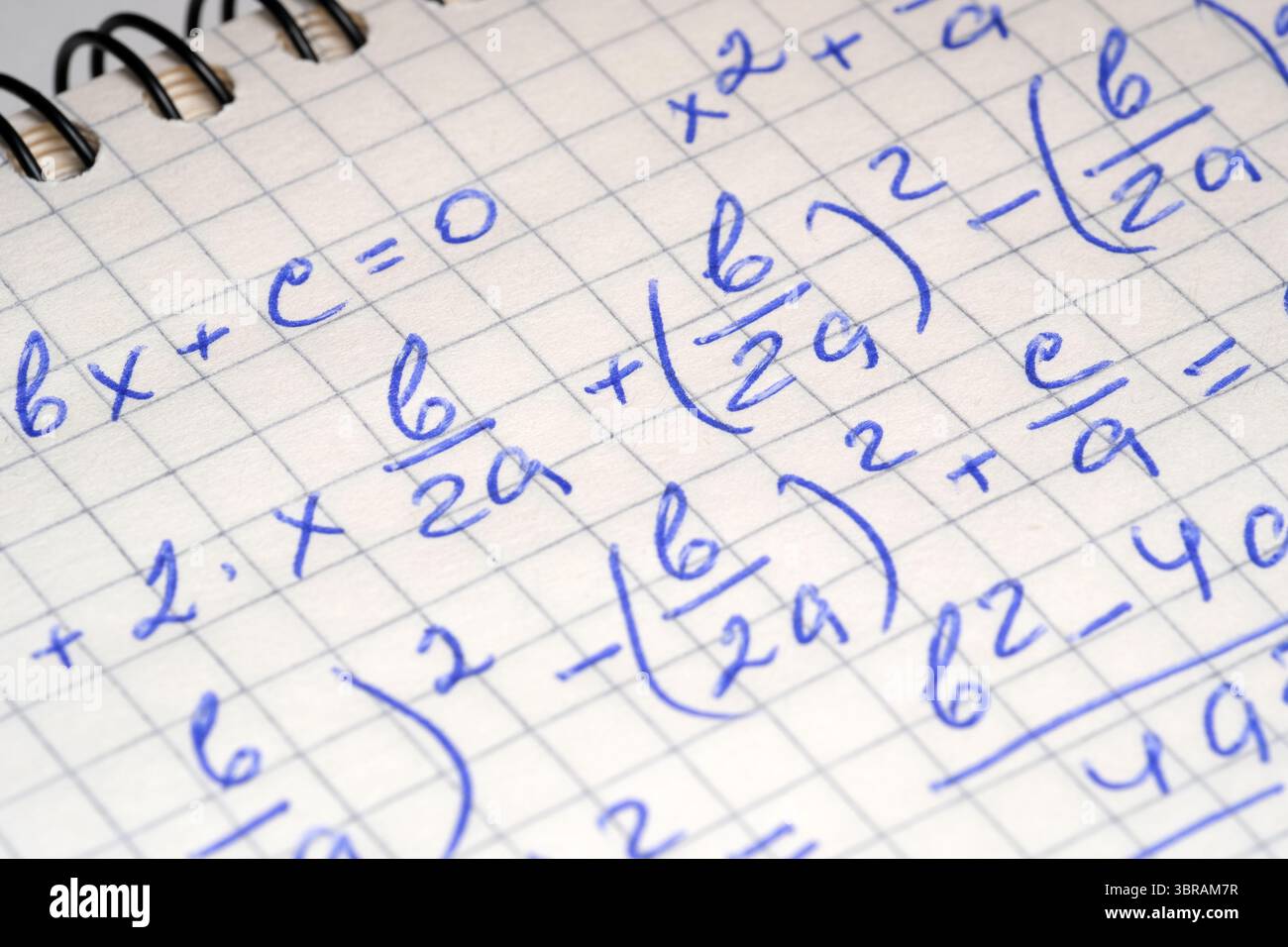 Handschriftliche Notizen zeigen algebraische Gleichungen und Berechnungen in einem Notizbuch. Stockfoto