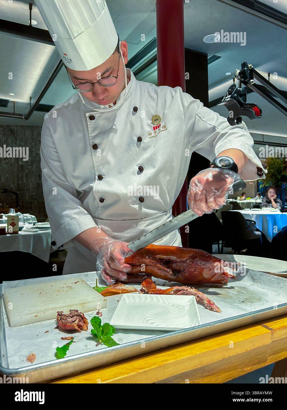 Shanghai, China, Porträt, chinesischer Küchenchef, in Uniform, Entenschnitzerei am Tisch im Speisesaal, chinesisches Restaurant, 'Peking Chamber' Stockfoto