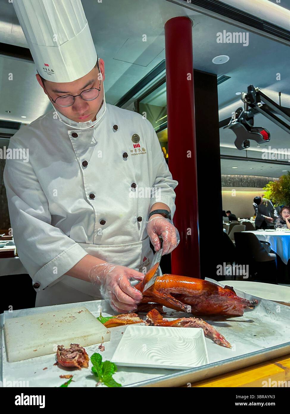 Shanghai, China, Porträt, chinesischer Küchenchef, in Uniform, Entenschnitzerei am Tisch im Speisesaal, chinesisches Restaurant, 'Peking Chamber' Stockfoto