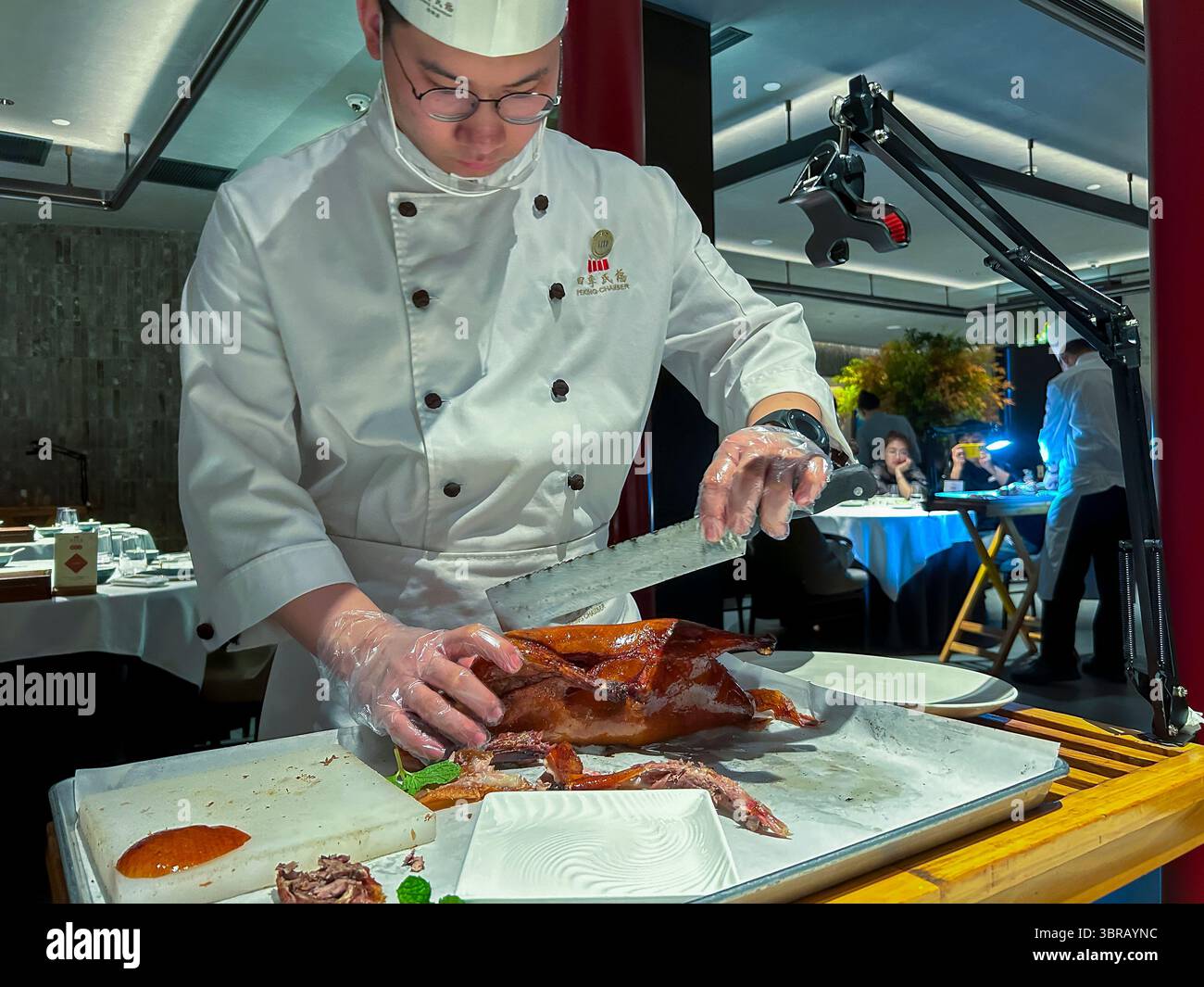 Shanghai, China, Porträt, chinesischer Küchenchef, in Uniform, Entenschnitzerei am Tisch im Speisesaal, chinesisches Restaurant, 'Peking Chamber' Stockfoto