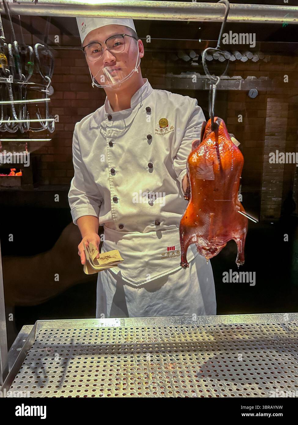 Shanghai, China, Porträt, chinesischer Küchenchef, in Uniform, Entenschnitzerei am Tisch im Speisesaal, chinesisches Restaurant, 'Peking Chamber' Stockfoto