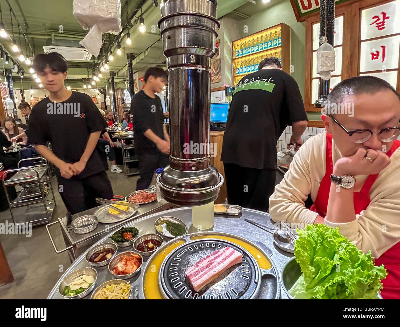 Shanghai, China, chinesische Restaurantarbeiter im koreanischen Barbecue-Restaurant, Essen auf dem Tisch Stockfoto