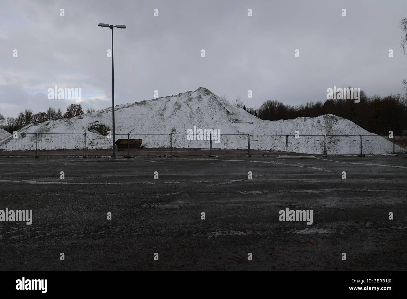 Schneebedeckter Hügel mit einem Zaun im Hintergrund Stockfoto