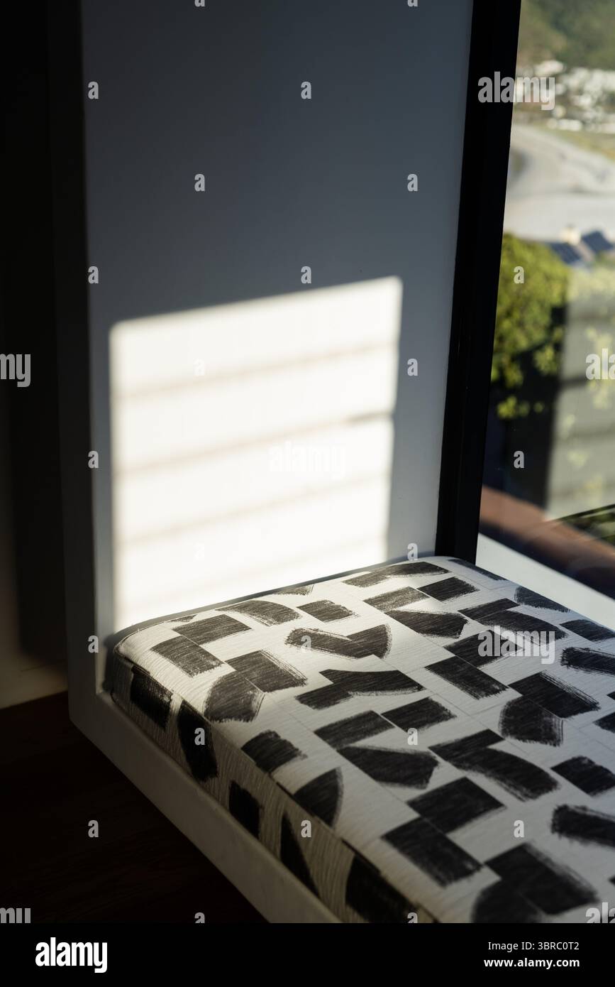 Das Sitzpolster der Sitzbank zeigt ein auffälliges schwarzes Pinselstrichmuster am Fenstersitz, das die Sicht auf den Hang freigibt Stockfoto