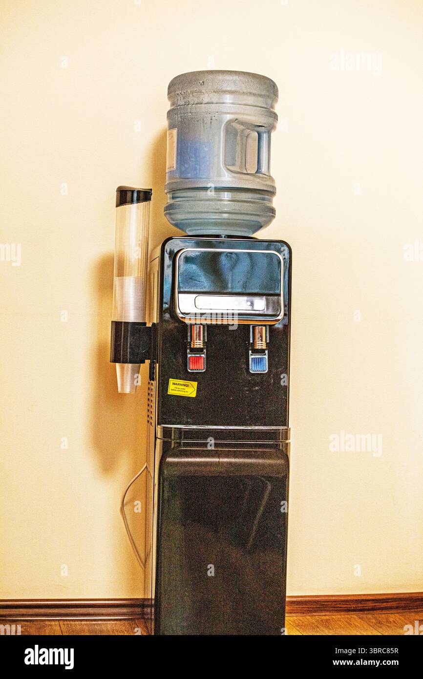 Flasche gereinigtes Trinkwasser mit heißer und warmer Regelung im Büro Stockfoto