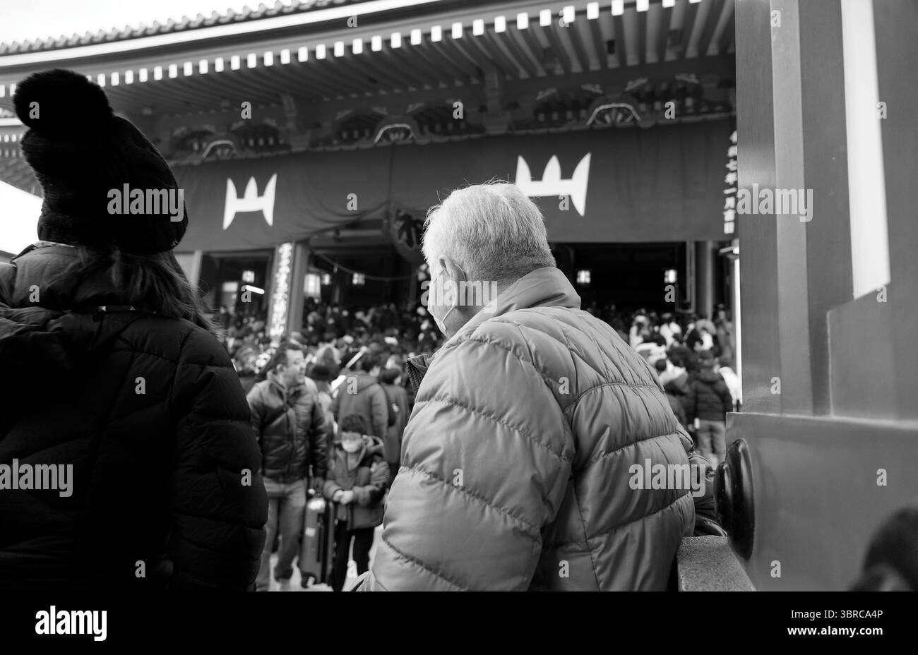Die monochrome Menschenmenge trotzt der Winterkälte am Eingang des Senso Ji Tempels Stockfoto