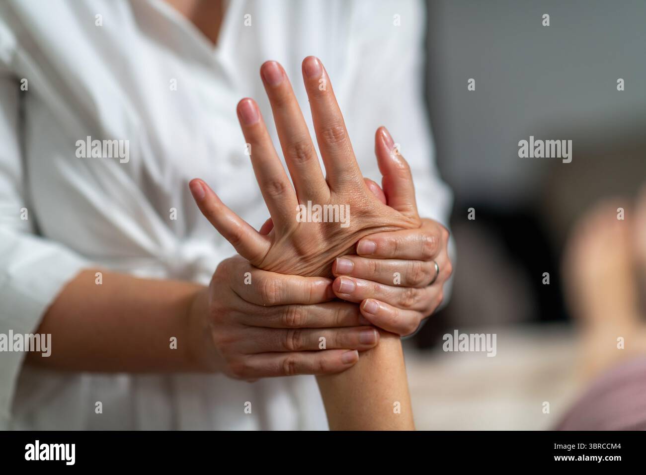 Frau erhält eine Handmassage, um Verspannungen zu lösen, die Durchblutung zu verbessern, Stress zu reduzieren und Entspannung zu fördern. Es entfernt auch tote Hautzellen, befreit verstopfte Poren und verbessert glattere, gesündere Haut. Stockfoto