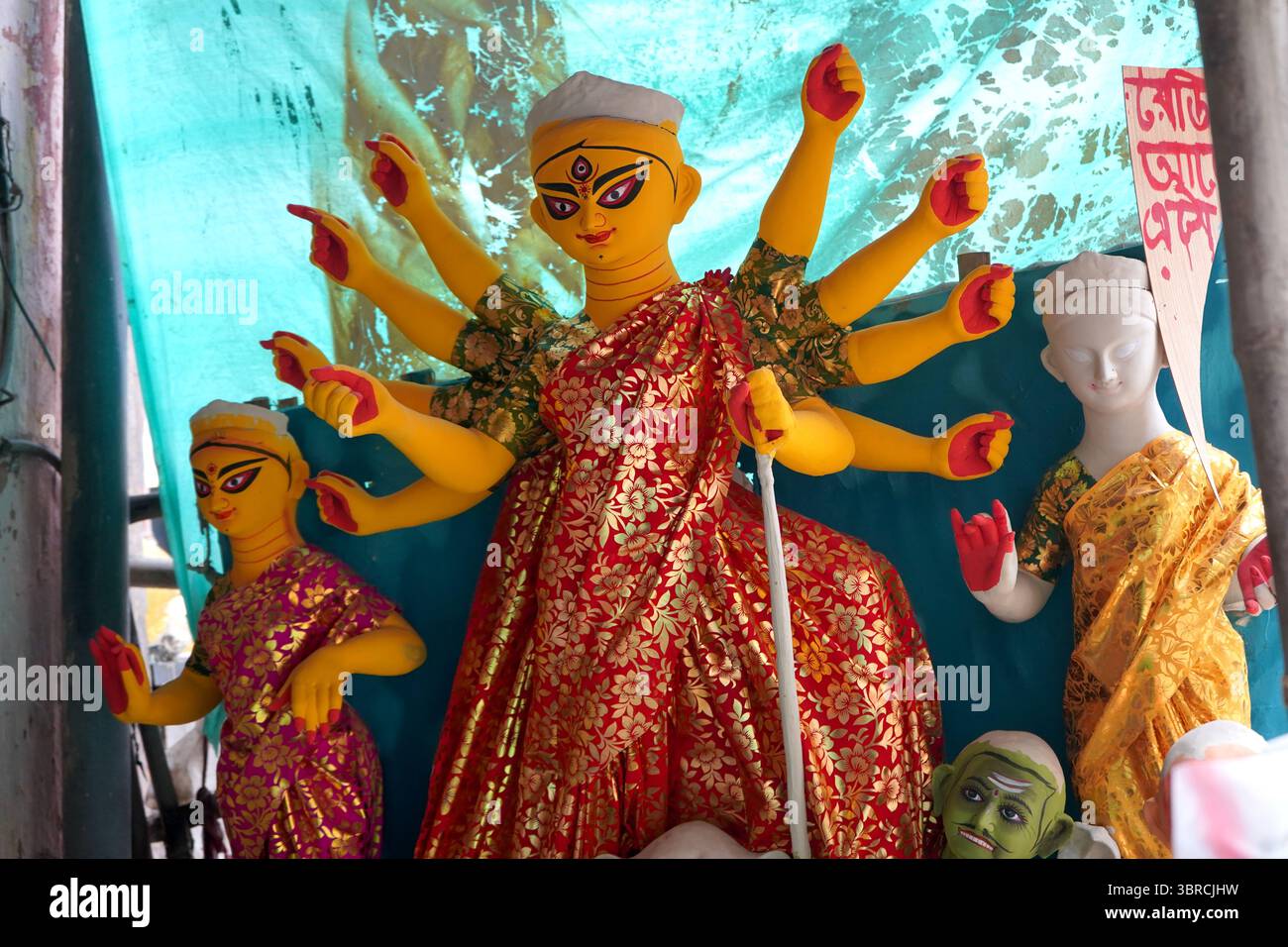 Das lebhafte gelbe Durga Idol wartet auf den Abschluss im Kumartuli Workshop Stockfoto