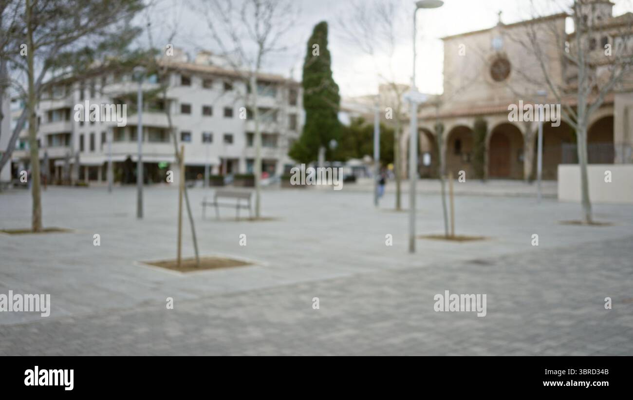 Verschwommene Straßenszene in einer mediterranen Altstadt mit defokussierter Architektur und leerem urbanem plaza unter bewölktem Himmel mit Bokeh-Effekt. Stockfoto
