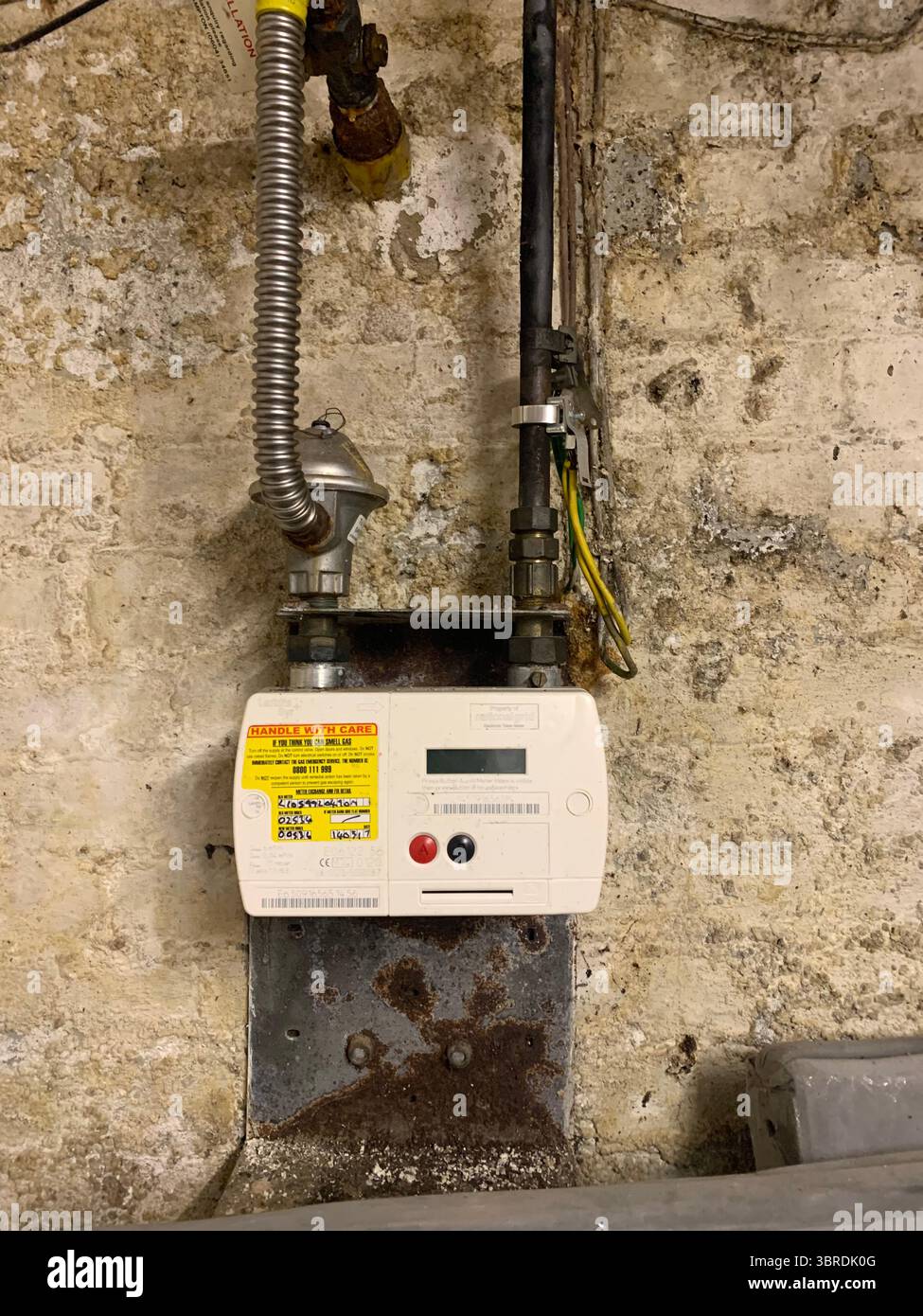 Alte elektrische Verkabelung Haupteinheit Gasbox Rohre Drähte Kabel schmutzig schmuddelig an der Wand in einem Keller Meter Gas Elektrizität Holzrahmen Elektrik UK Stockfoto