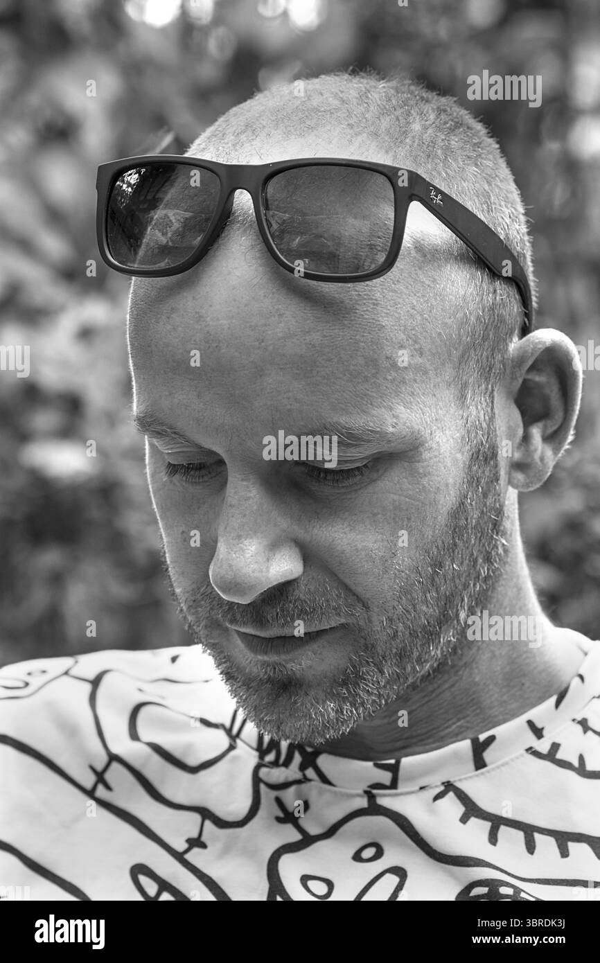 Junger Mann mit Bart und Sonnenbrille auf der Stirn, schwarz-weiß, Baden-Württemberg, Deutschland Stockfoto