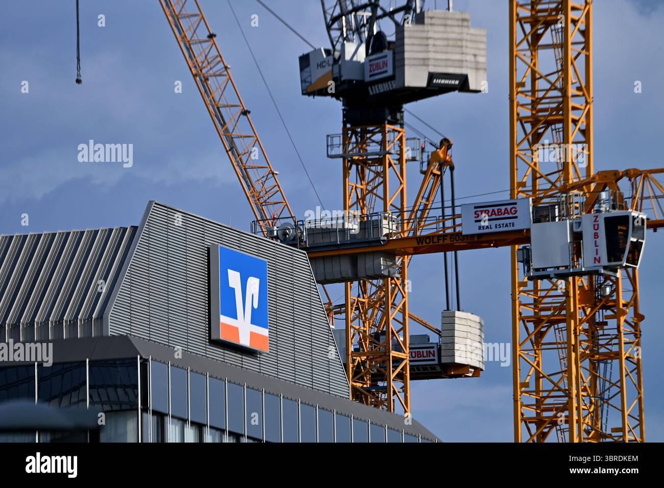 München, Deutschland. Juli 2025. Betrefffoto: Volksbank Raiffeisenbank EG, Logo, Banklogo, Firmenlogo, Firmenlogo. Dahinter befinden sich Baukräne, Baustelle? Quelle: dpa/Alamy Live News Stockfoto
