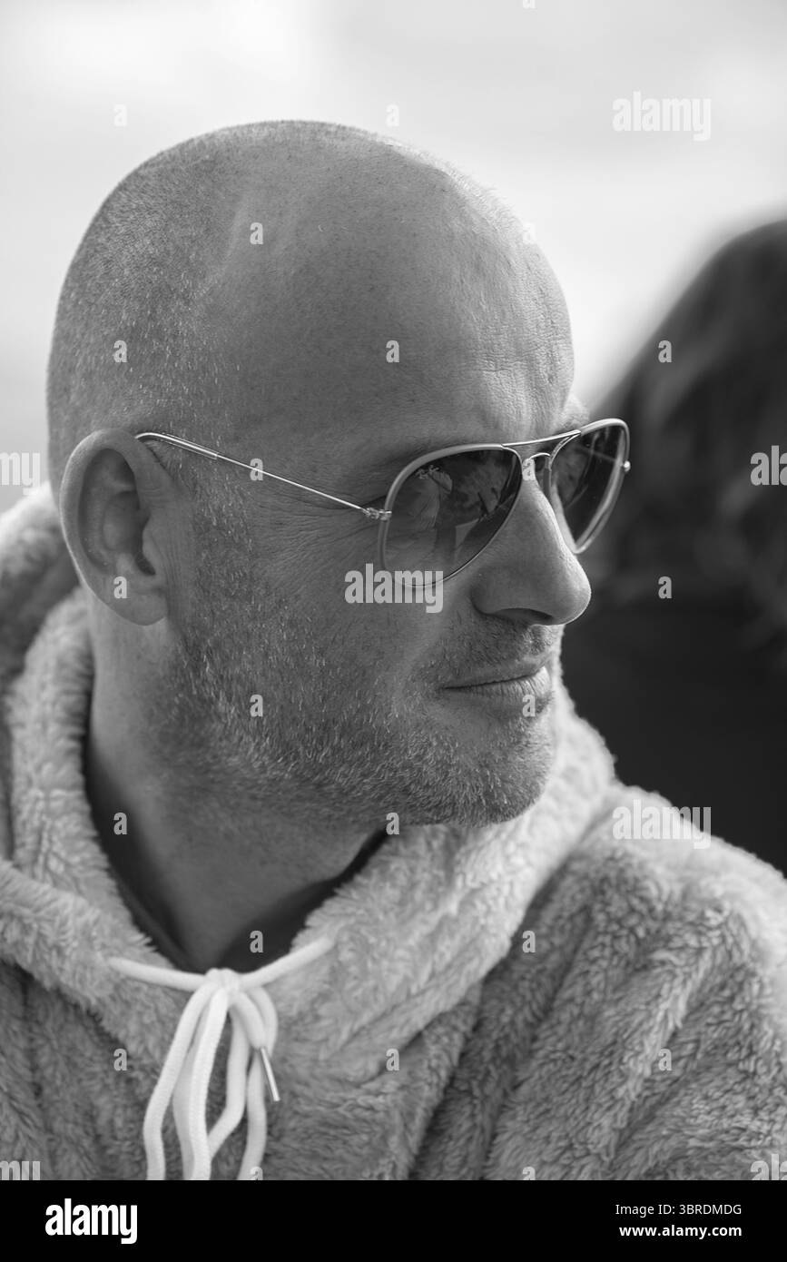 Porträt eines jungen Mannes mit Sonnenbrille und flauschiger Jacke, schwarz-weiß, Baden-Württemberg, Deutschland Stockfoto