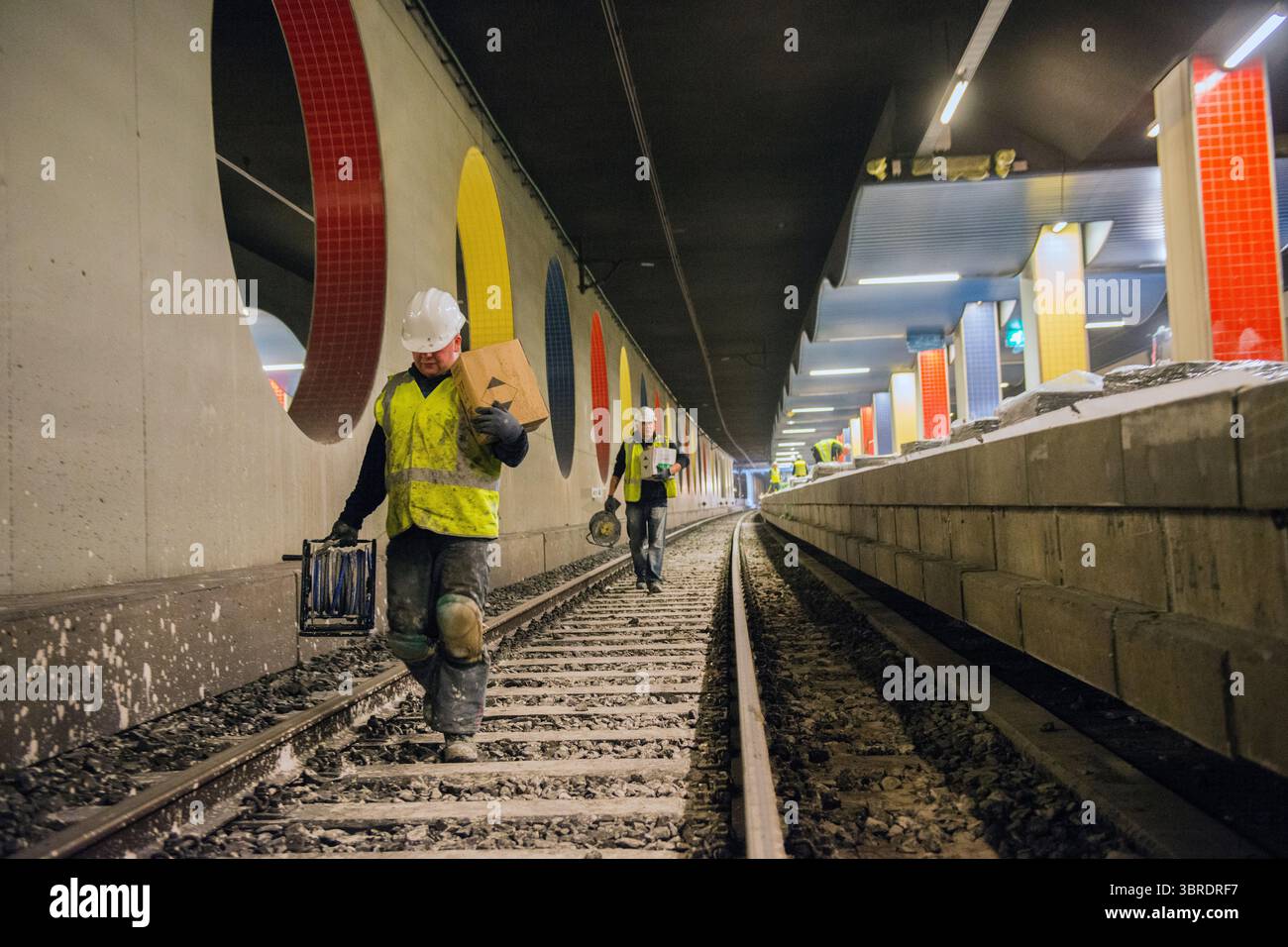 Rotterdam, Niederlande. Zwei männliche Bauarbeiter und Angestellte eines ProRail-Subunternehmers, die an der Instandhaltung und Instandsetzung der Bahngleise des Willemspoor-Tunnels in Rotterdam, Niederlande, arbeiten. Stockfoto