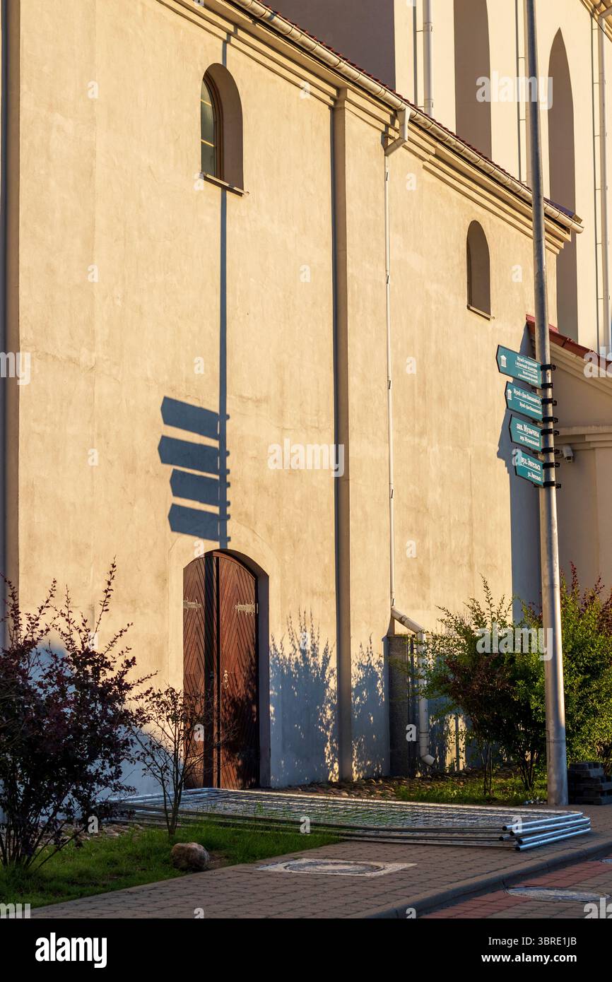Alte Richtungsschilder werfen Schatten auf die nahe Wand Stockfoto