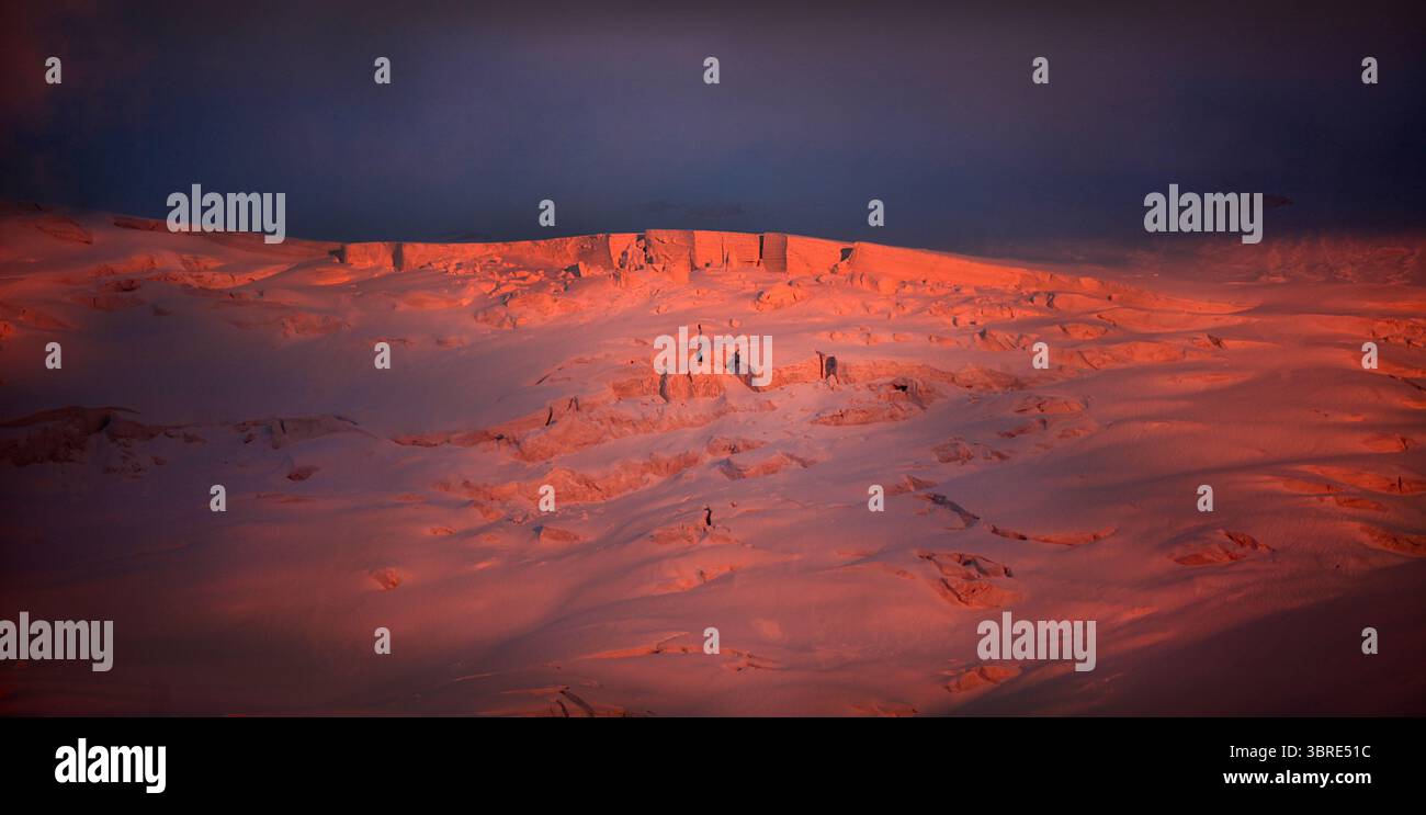 Feuerroter Gletscher brennt wie Feuer bei Sonnenuntergang über 6.000 m auf dem Lenin Peak. Atemberaubender Kontrast zwischen tiefblauem Himmel und sonnendurchflutetem Eis. Rerikh-Stil Stockfoto