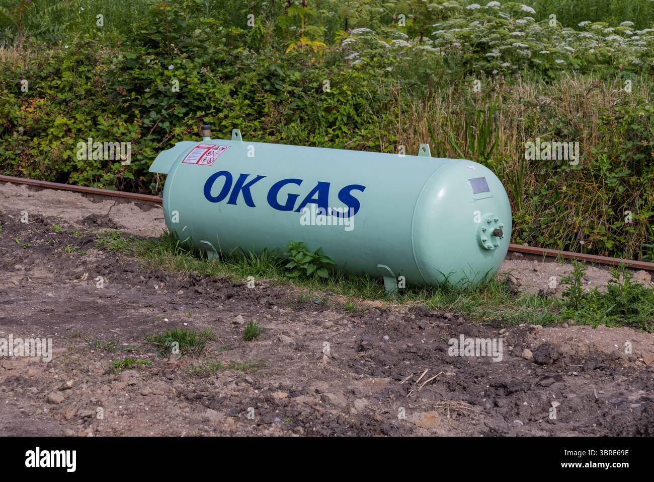 Ein großer, hellblauer Propantank mit „OK GAS“, der draußen auf dem Boden sitzt. . Utrecht, Niederlande. 11. Juli 2025. Stockfoto