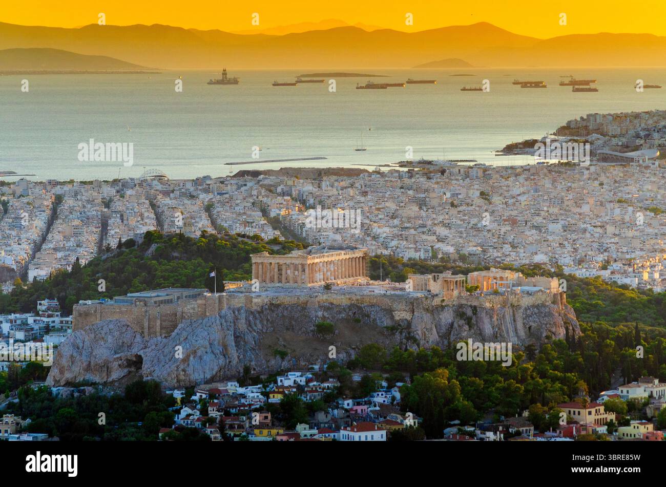 Golden Hour Abendblick auf den Parthenon und die Akropolis und das Erechtheion vom Lycabettus-Hügel in der Innenstadt von Athen, Griechenland mit der Saronischen Golfinsel Stockfoto