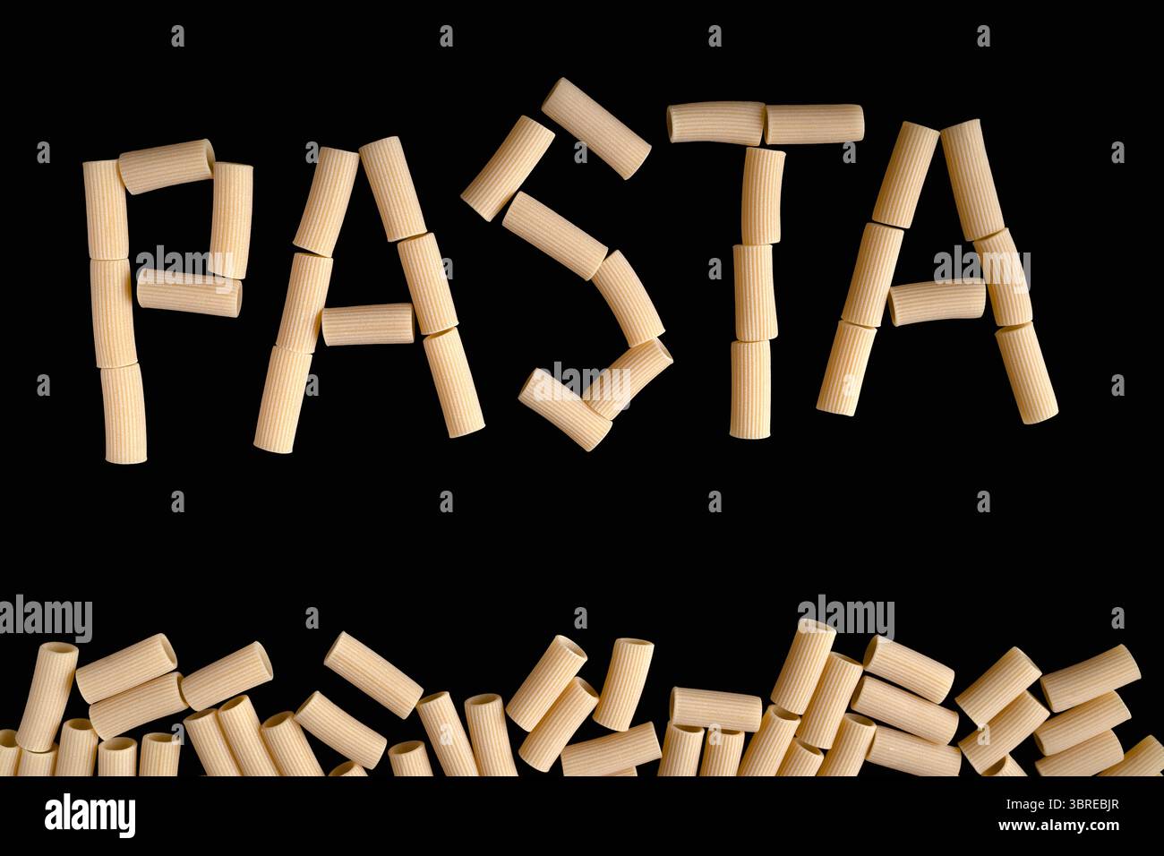 Das Wort „PASTA“ wurde mit Rigatoni-Nudelröhrchen mit einem Rand von zusätzlichen Nudelstücken am unteren Rand ausgesprochen Stockfoto