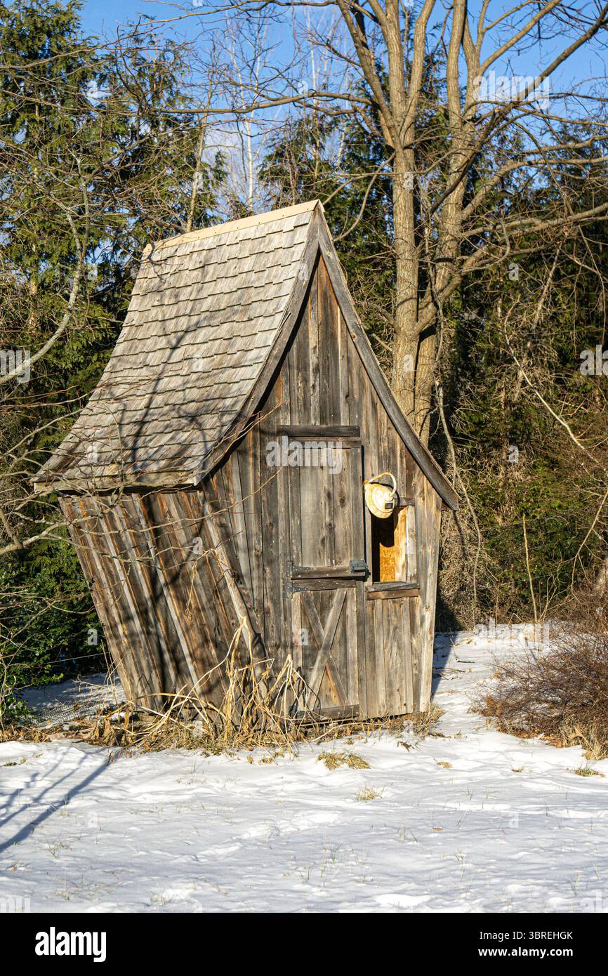 Kleine Holzhütte im Bundesstaat New York mit Schnee und blanken Ästen Stockfoto