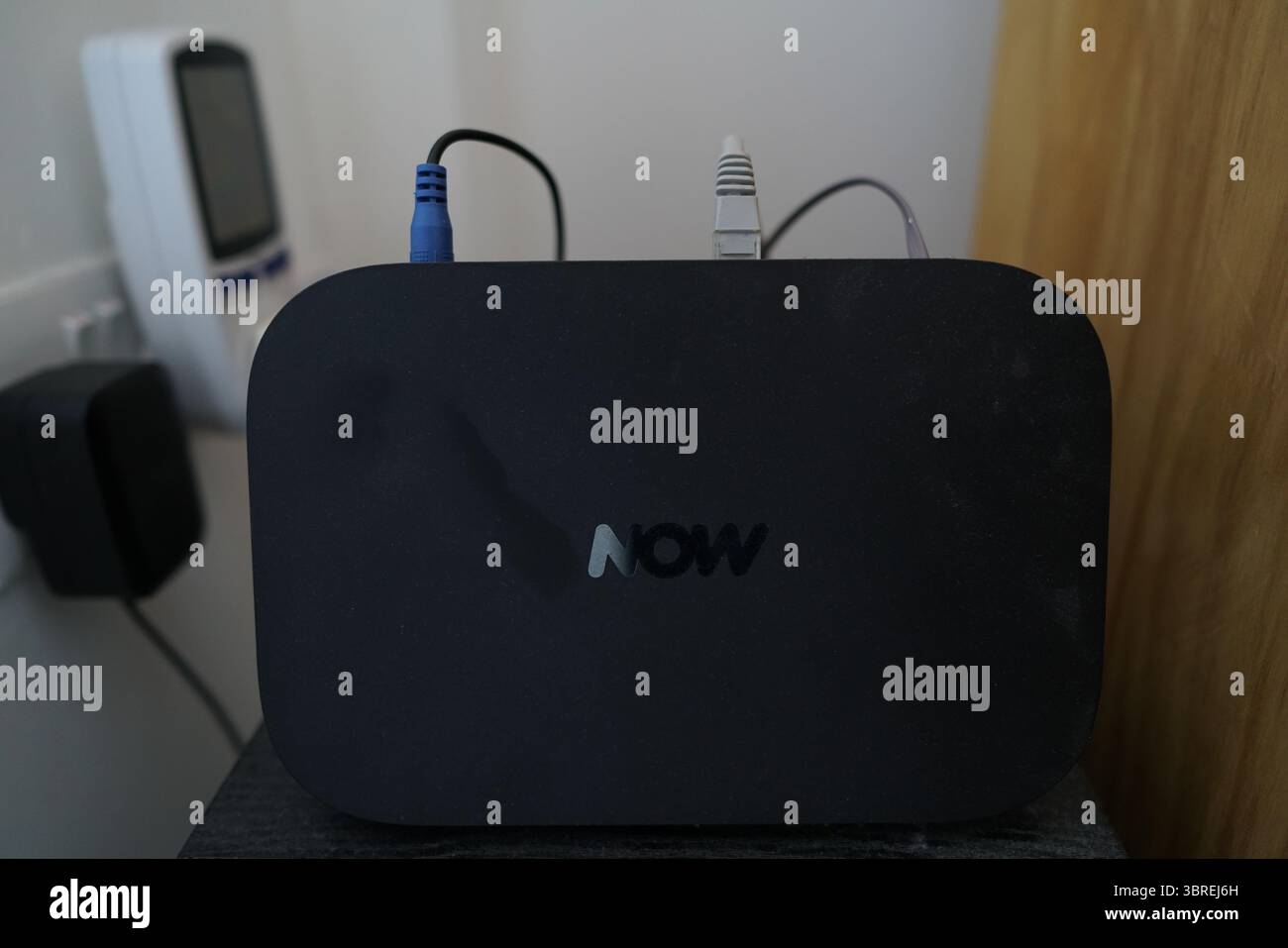 Schwarzer Breitband-Router mit mehreren Kabeln, die an einem Tisch angeschlossen sind. Dorking, England Stockfoto