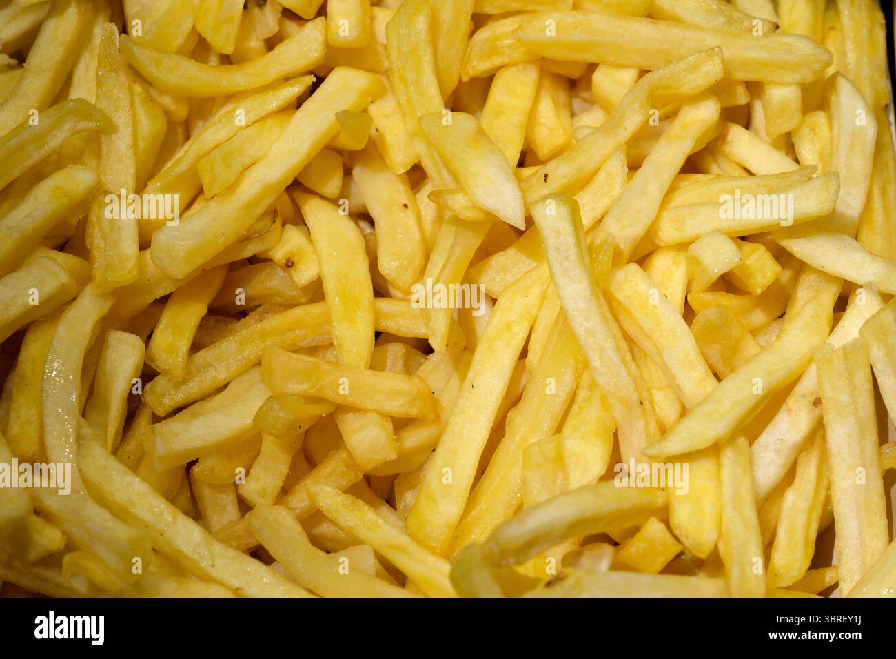 Goldene Pommes Frites stapeln sich hoch und fangen die Essenz des Wohlgefühls ein. Stockfoto