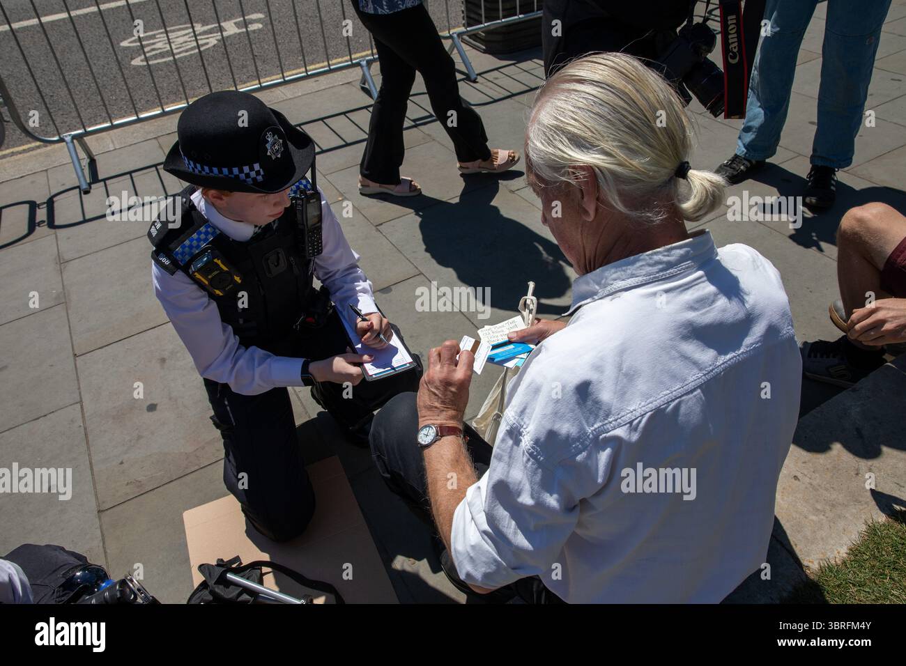 Ein Unterstützer der Palästinensischen Aktion wird während der Kundgebung von einem Metropolitanpolizisten verhaftet. Anhänger der kürzlich verordneten Terrororganisation Palästinensische Aktion protestierten auf dem Parliament Square Westminster. Da die Gruppe als terroristische Bedrohung eingestuft wird, kann jeder, der Unterstützung zeigt, verhaftet und verfolgt werden. Stockfoto