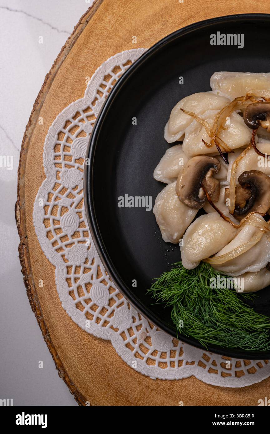 Traditionelle Knödel mit Pilzen und Kräutern auf Teller Stockfoto