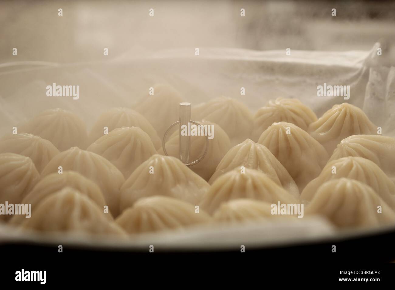 Dampfende heiße, gedämpfte Teigtaschen, die zu Hause zubereitet werden Stockfoto