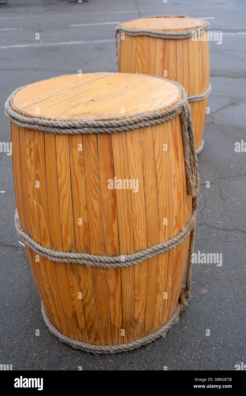 Zwei rustikale Holzfässer ruhen auf einer Marktstraße, die Neugier und Charme einladen. Stockfoto