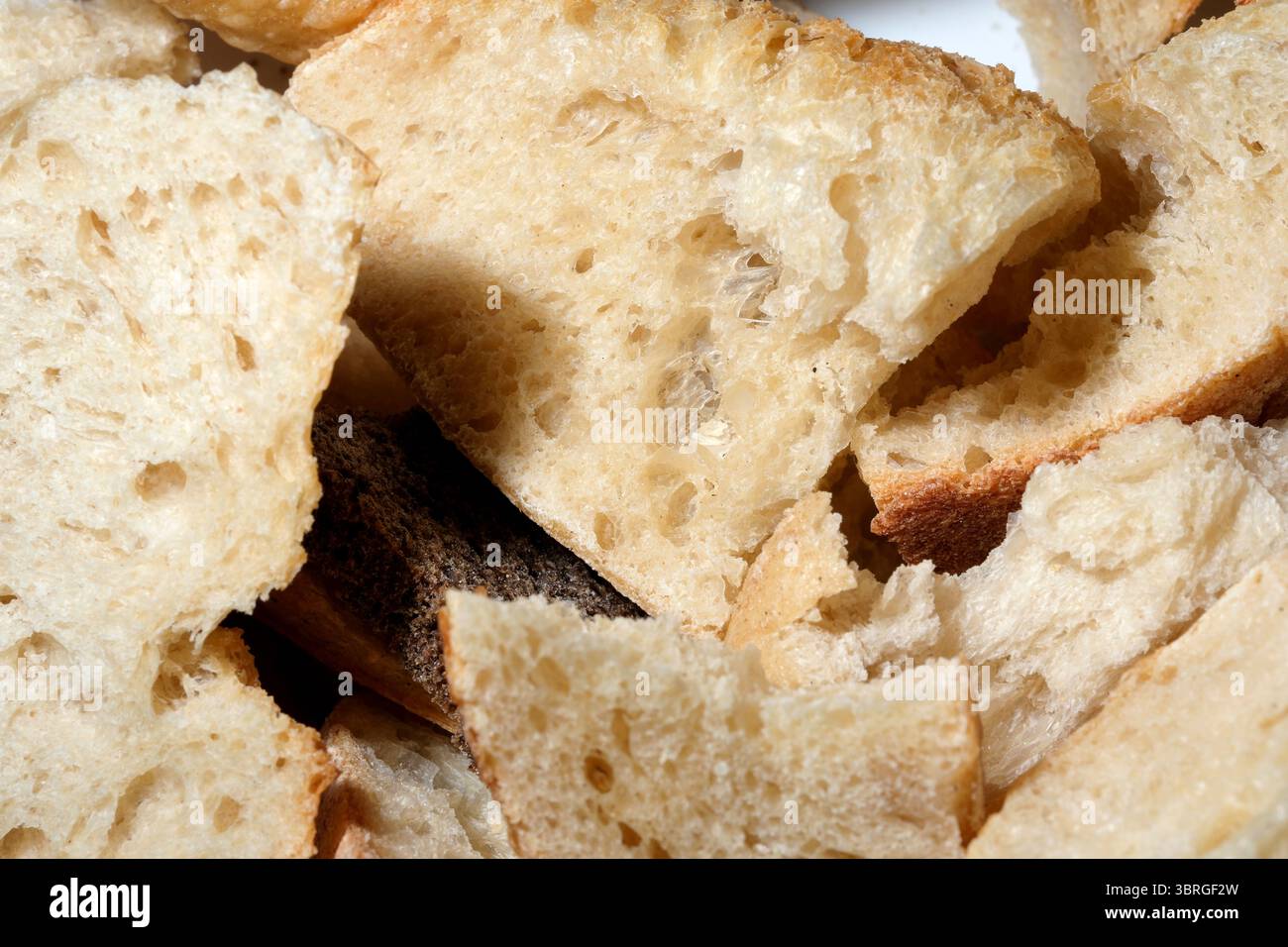 Handwerkliche Brotstücke lagen einladend auf einem weißen Teller. Stockfoto