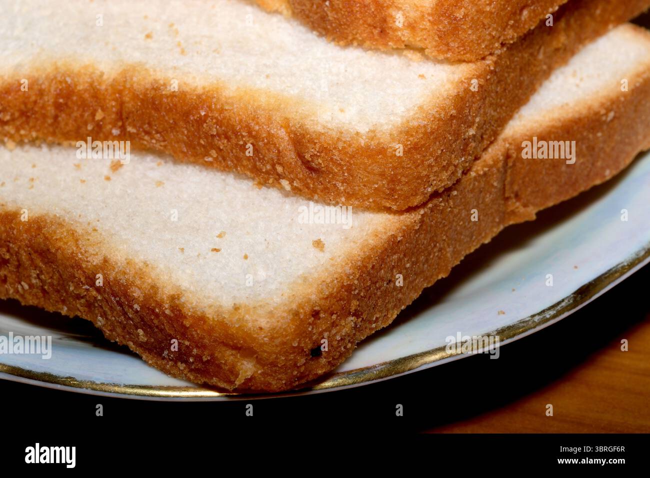 Warme Scheiben hausgemachtes Brot ruhen auf einem schönen Teller, bereit zum Genießen. Stockfoto