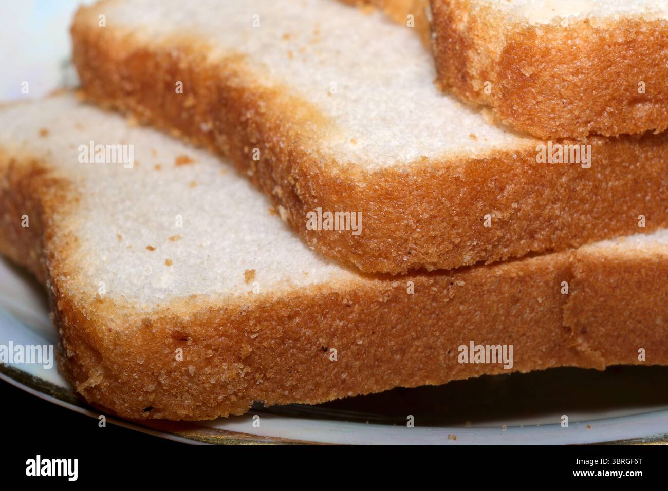 Frisch gebackene Brotscheiben auf einem eleganten Teller warten auf Genuss. Stockfoto