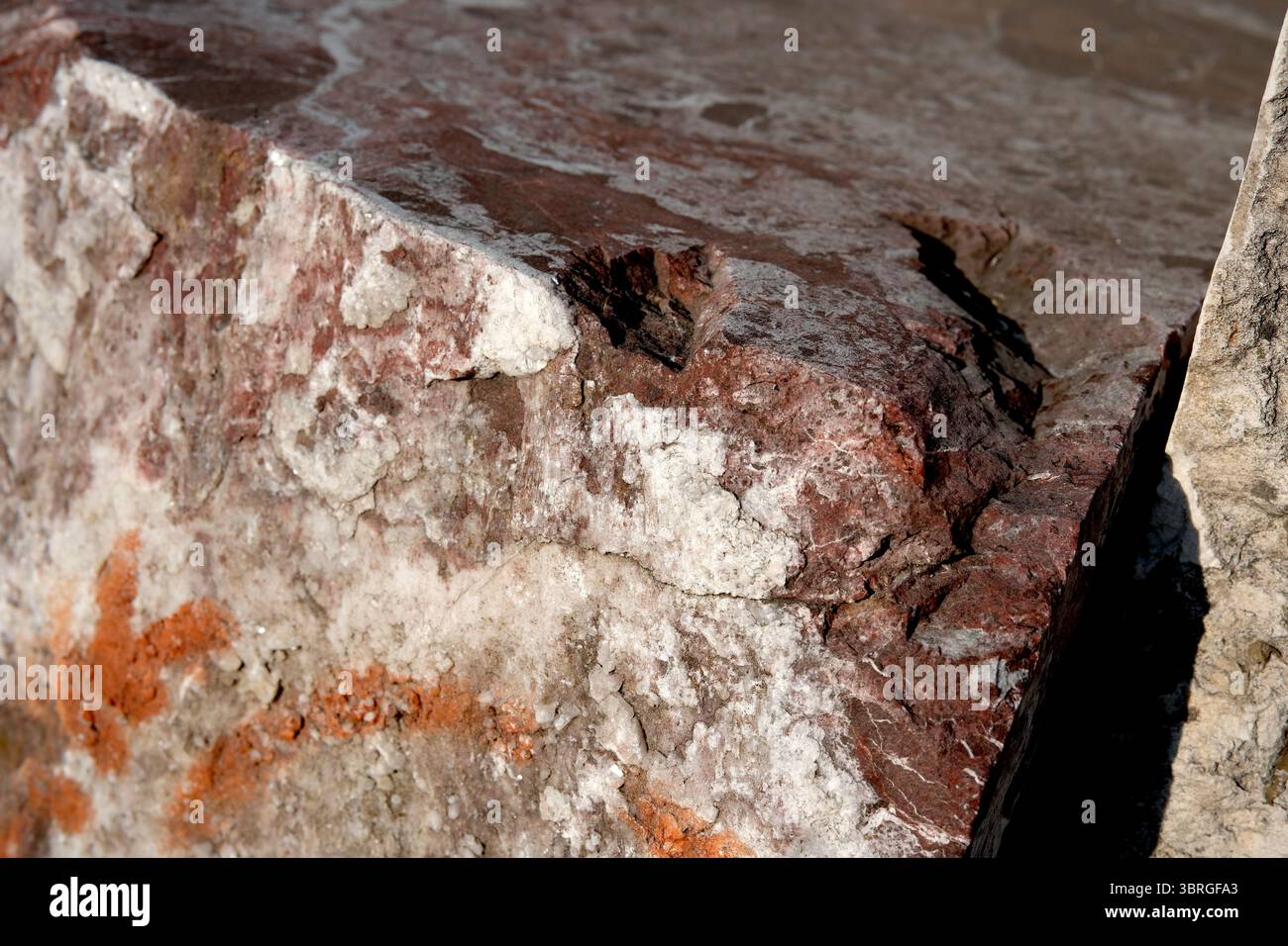 Sonnendurchflutete, strukturierte Felsenschimmern mit leuchtenden Farben und Mustern. Stockfoto