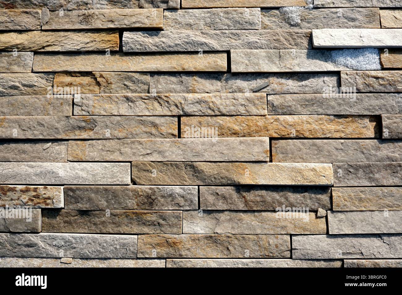 Eine Nahansicht einer Steinwand mit satten Farben und Texturen. Stockfoto