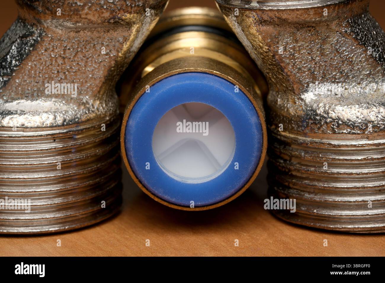 Nahaufnahme von Messinginstallationsteilen, die Details und Texturen hervorheben. Stockfoto