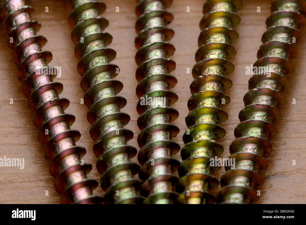 Bunte Schrauben auf Holz unterstreichen handwerkliches Können. Stockfoto