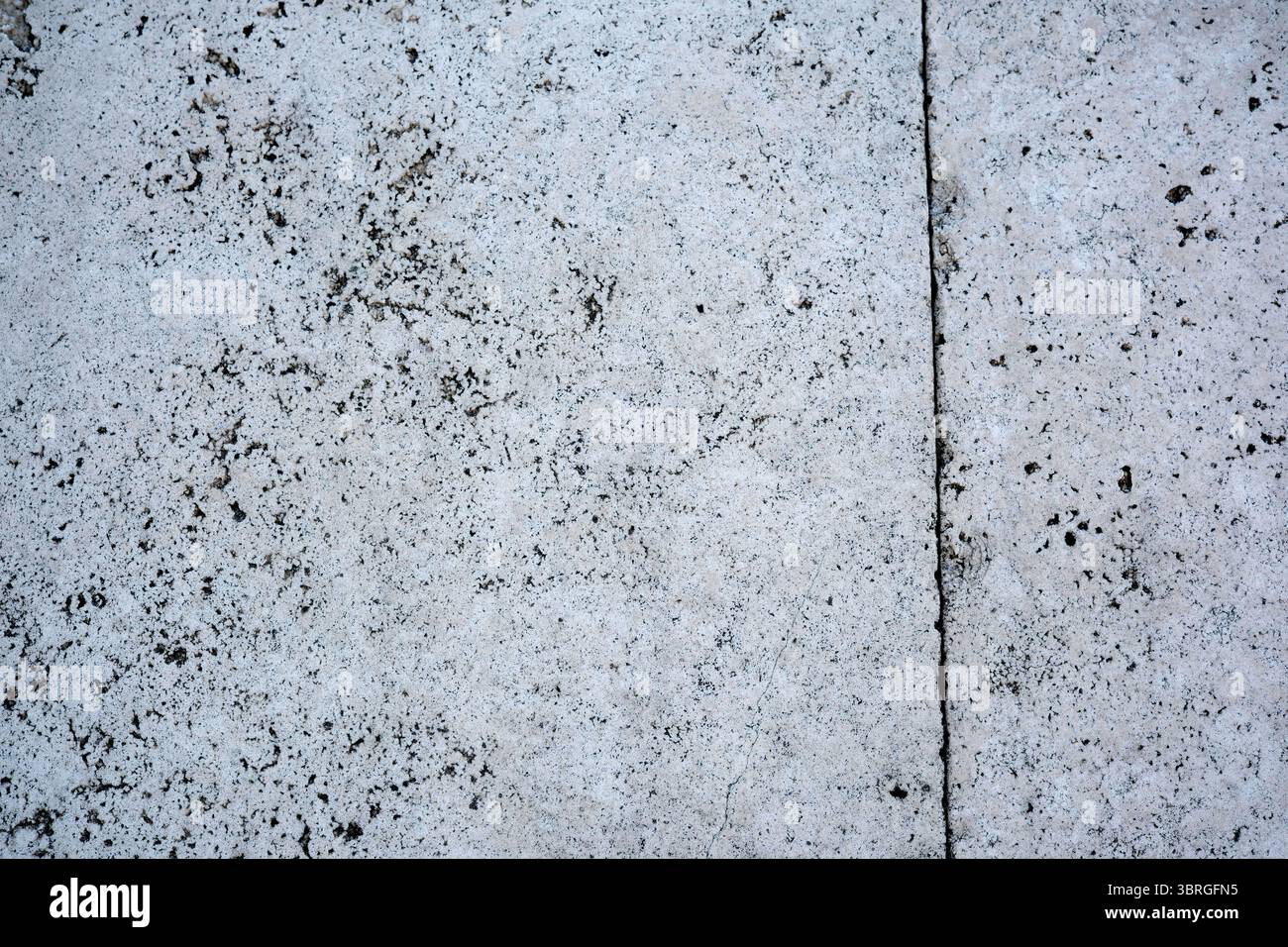 Strukturierter Beton zeigt natürliche Muster auf einem Bürgersteig der Stadt. Stockfoto