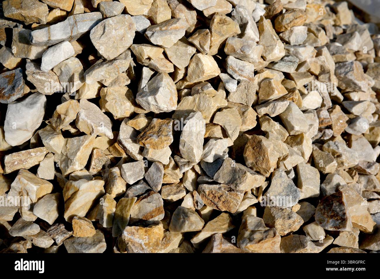Das Sonnenlicht unterstreicht die einzigartigen Strukturen und Farben der Kiesfelsen. Stockfoto