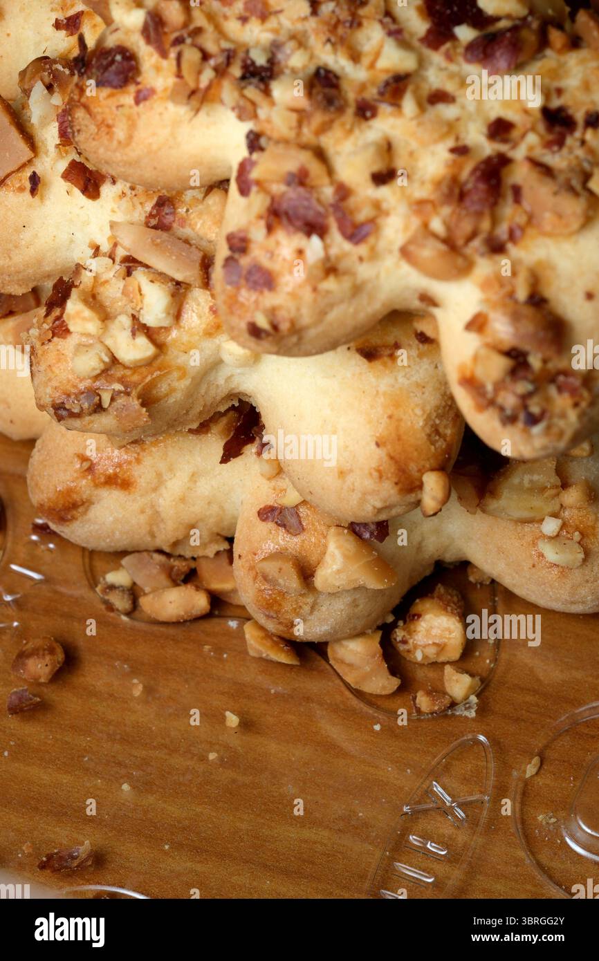 Golden Baked Delights sind kunstvoll gestapelt und zeigen eine großzügige Schicht zerstoßener Nüsse auf der Oberseite. Die warme Atmosphäre erinnert an einen hausgemachten, einladenden Saibling Stockfoto