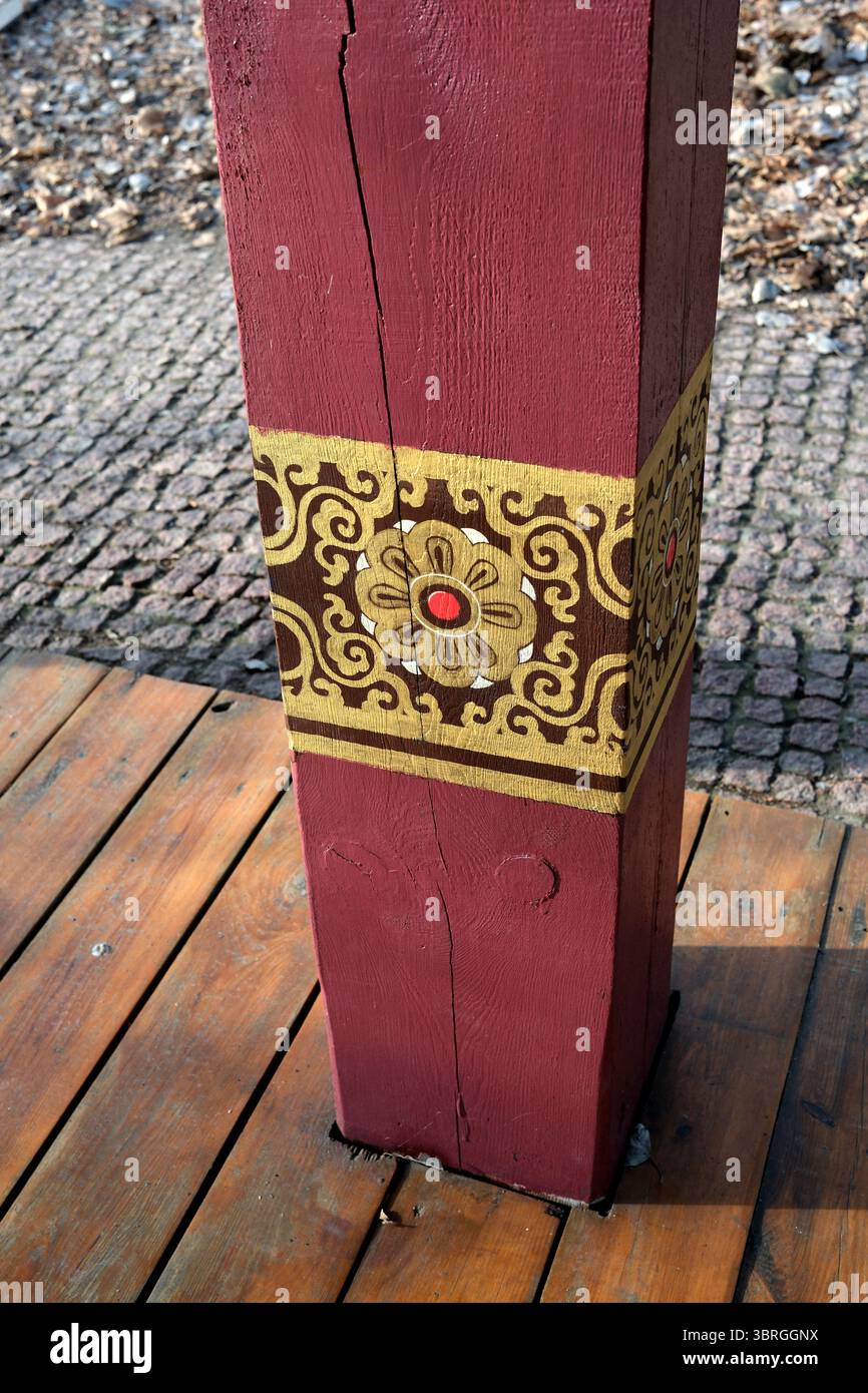 Farbenfrohe Muster und Texturen erwecken einen rustikalen Holzpfosten zum Leben. Stockfoto