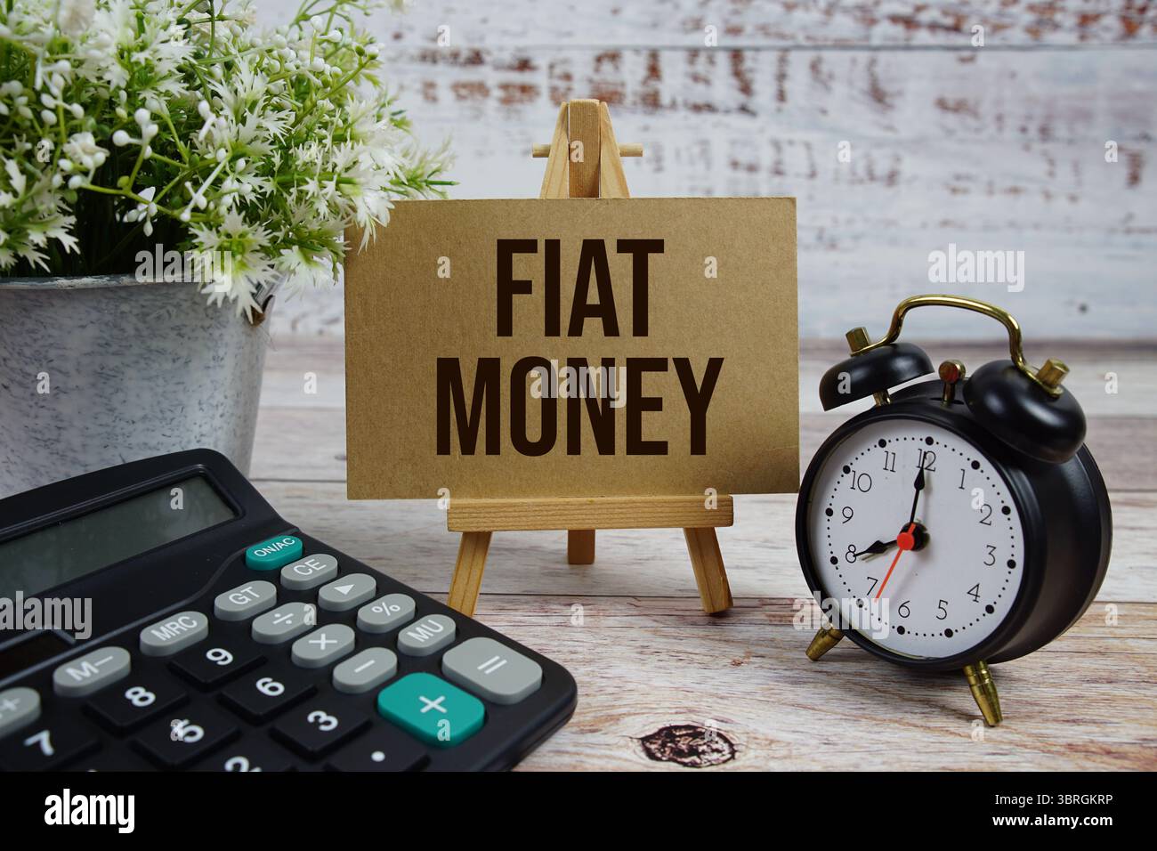 Fiat-Geldtext mit Wecker und Taschenrechner auf hölzernem Hintergrund Stockfoto