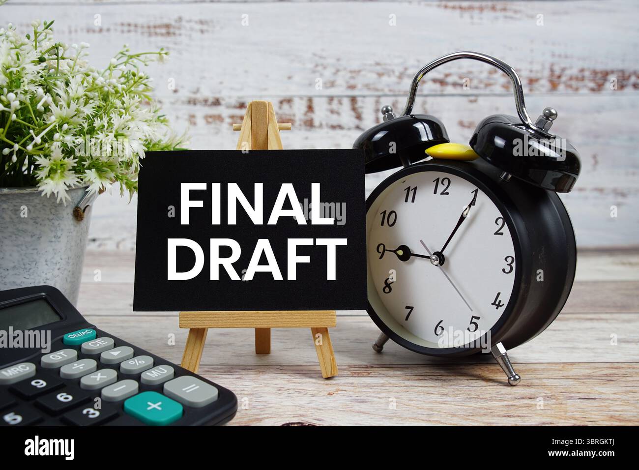 Endgültiger Textentwurf mit Wecker und Taschenrechner auf hölzernem Hintergrund Stockfoto