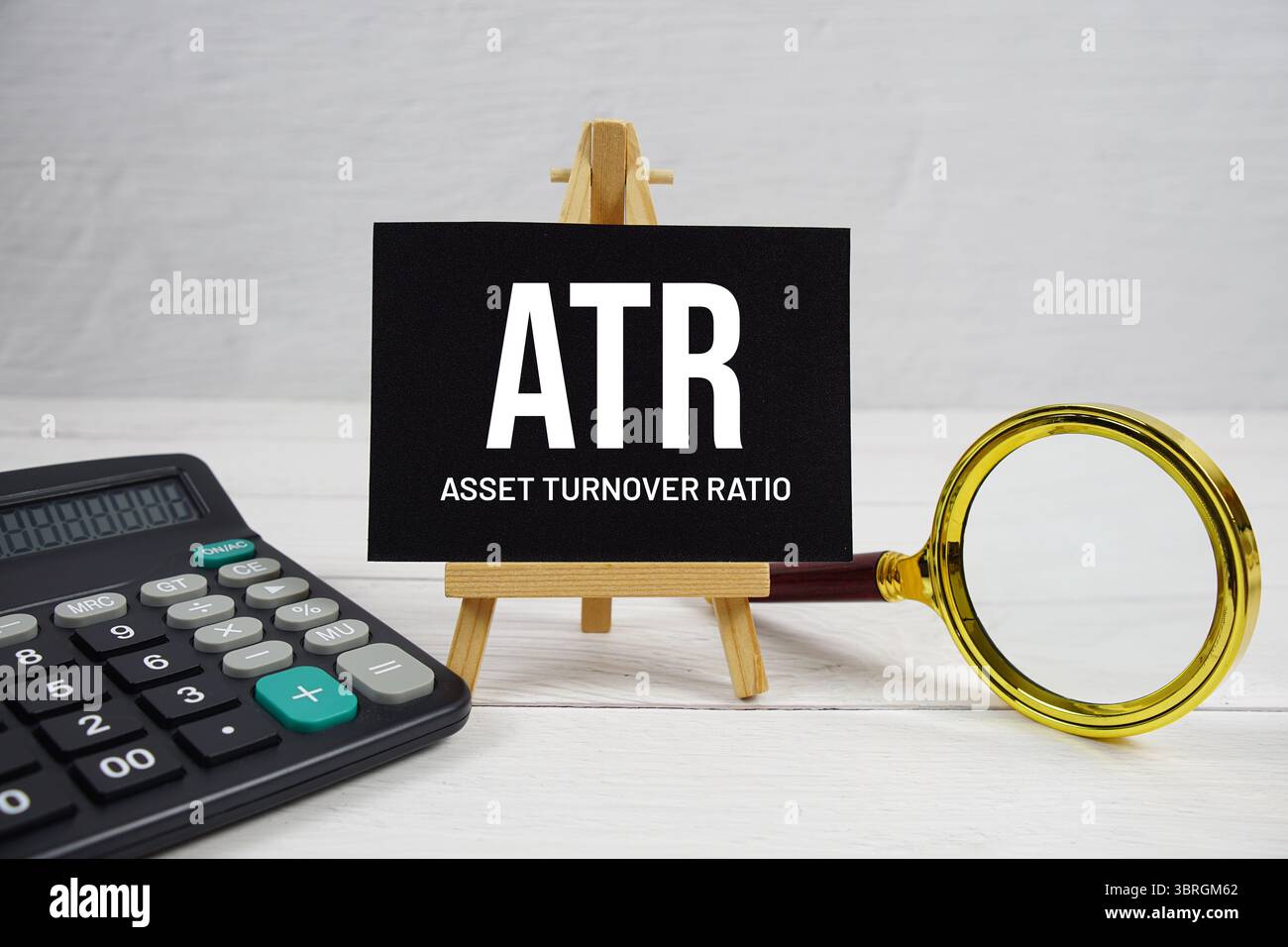 ATR-Abkürzung für Asset Sales Ratio Text mit Lupe und Rechner auf hölzernem Hintergrund Stockfoto