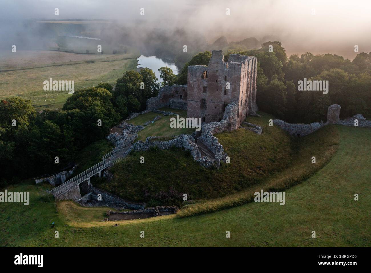 Norham Castle eine der wichtigsten Grenzburgen im Sommernebel am Fluss Tweed Stockfoto